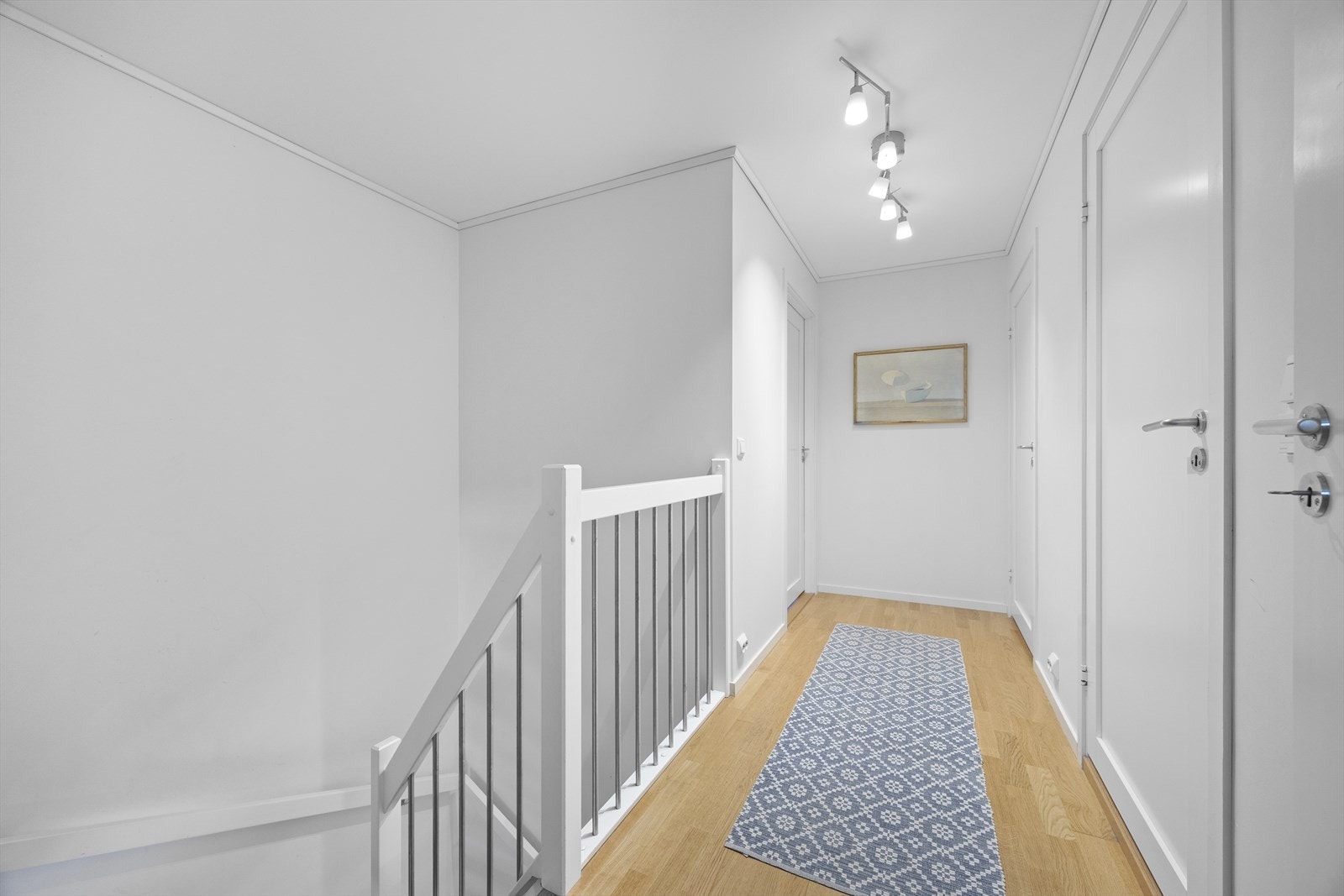 Lys trappegang med malt rekkverk gir en åpen forbindelse mellom etasjene. Galleribilde