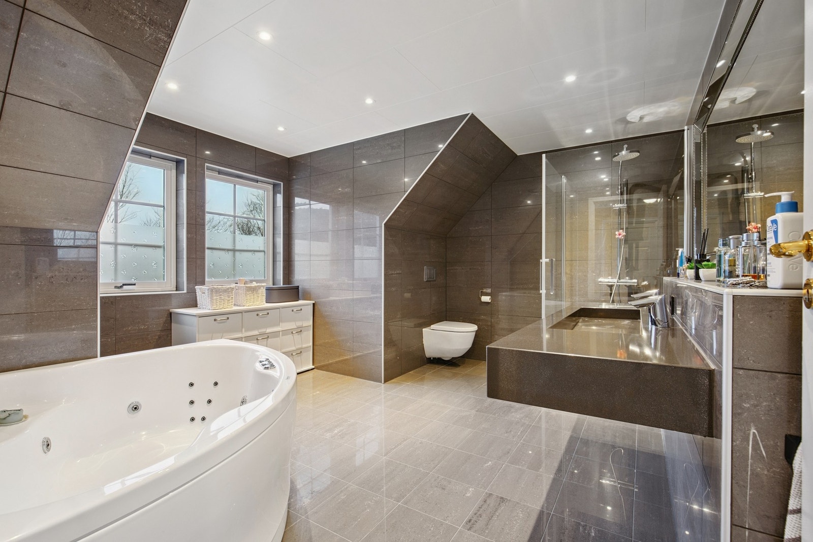 Boblebadekar og vegghengt wc. Flislagt på gulv og vegger - stilrent og lekkert! Galleribilde