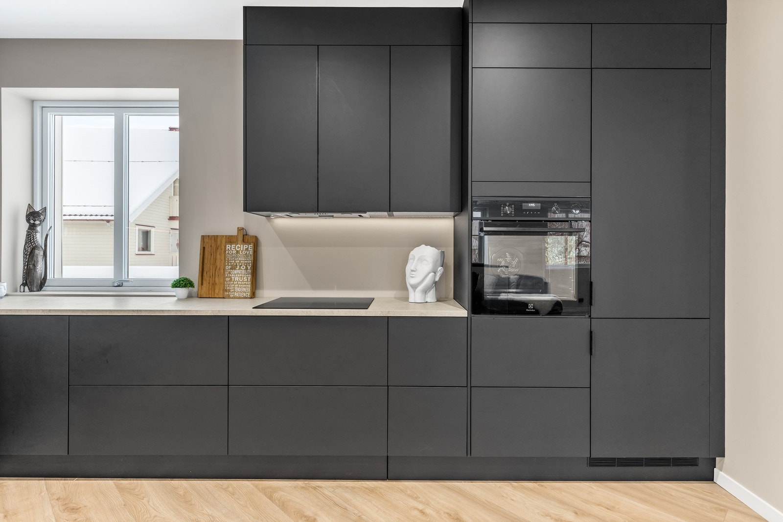 Innredningen har integrerte hvitevarer, herunder kjøl/fryseskap, oppvaskmaskin, induksjonstopp og stekeovn Galleribilde