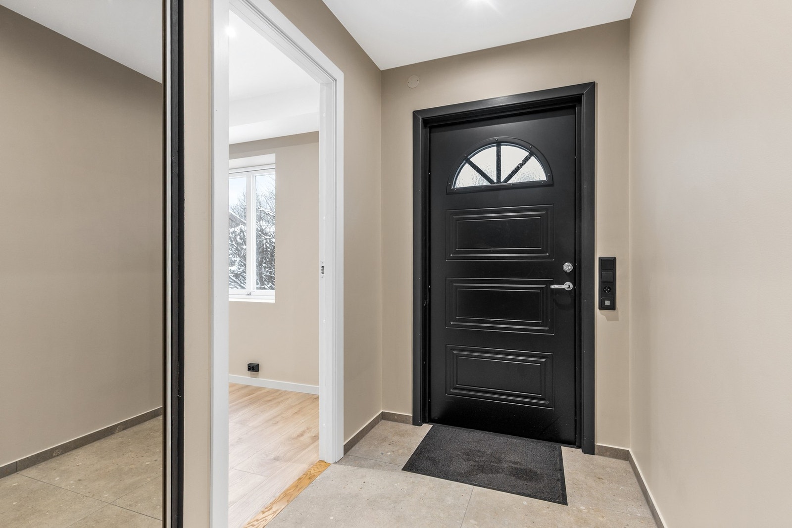 Entréen har flislagt gulv med elektriske varmekabler og downlights i himling Galleribilde