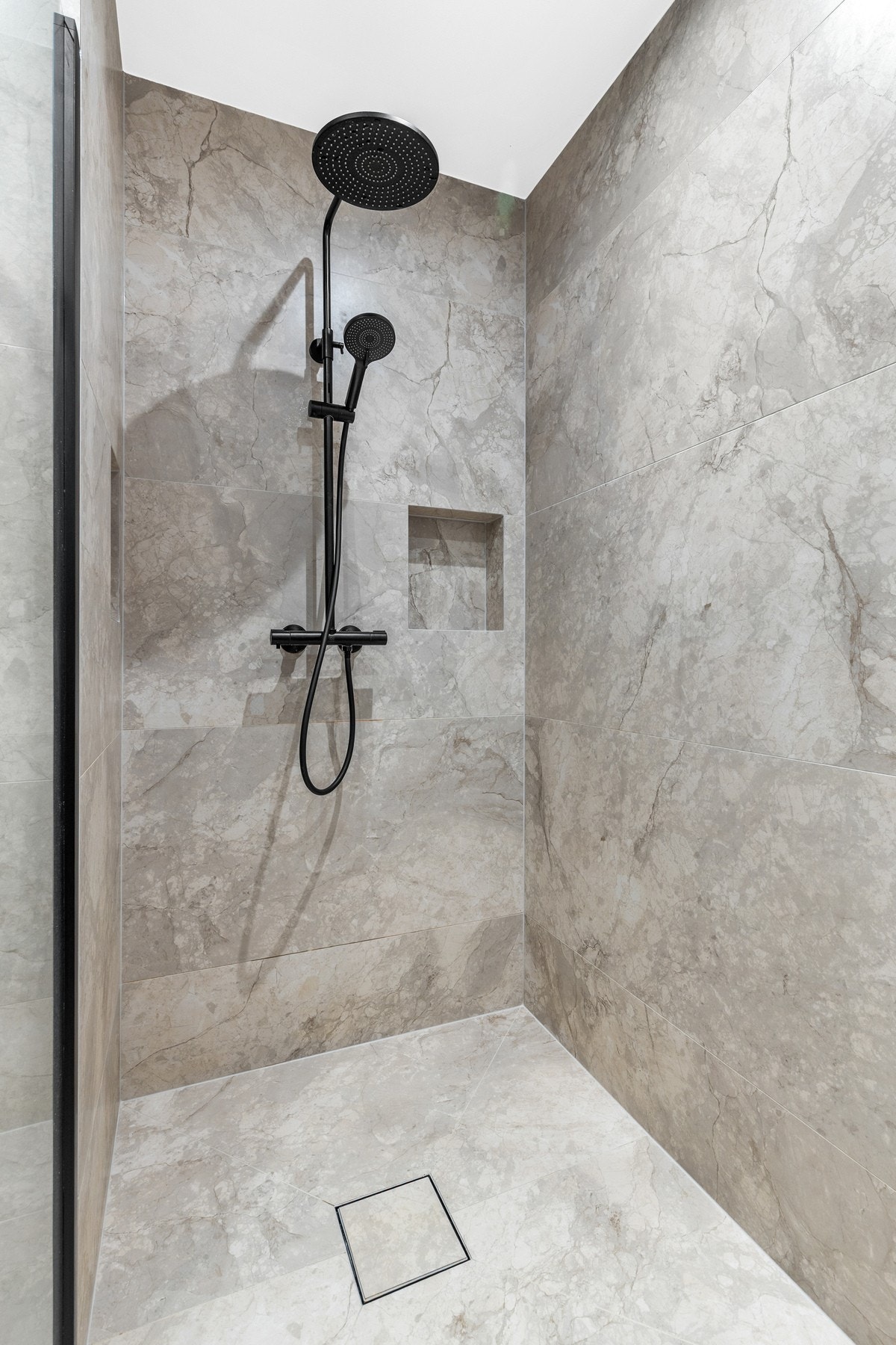 Videre er det etablert dusjhjørne med svart dusjarmatur og regndusj Galleribilde