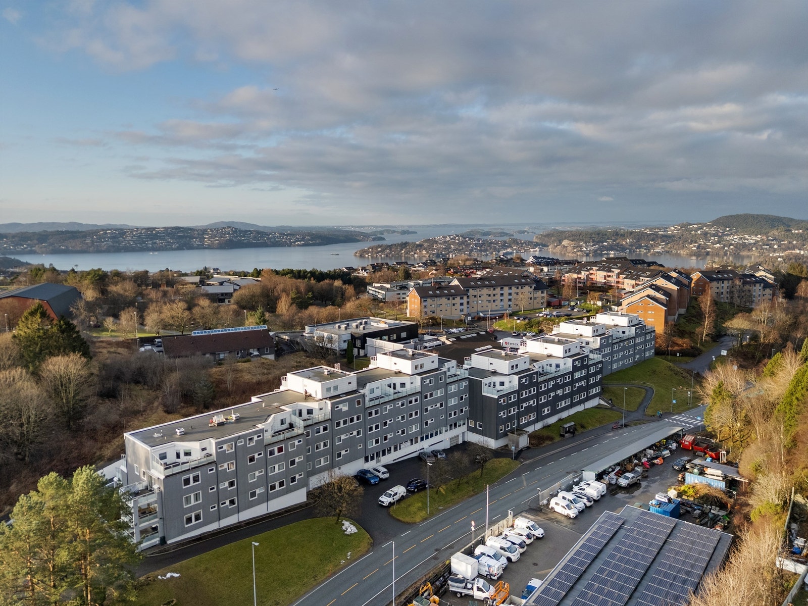 Dronefoto over byggets bakside og omkringliggende nabolag Galleribilde