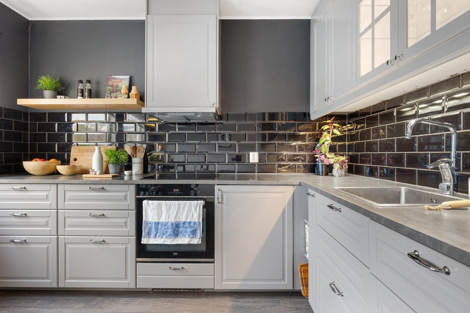 Moderne kjøkken med integrerte hvitevarer som platetopp, stekeovn og oppvaskmaskin, med et tidløst materialvalg Galleribilde