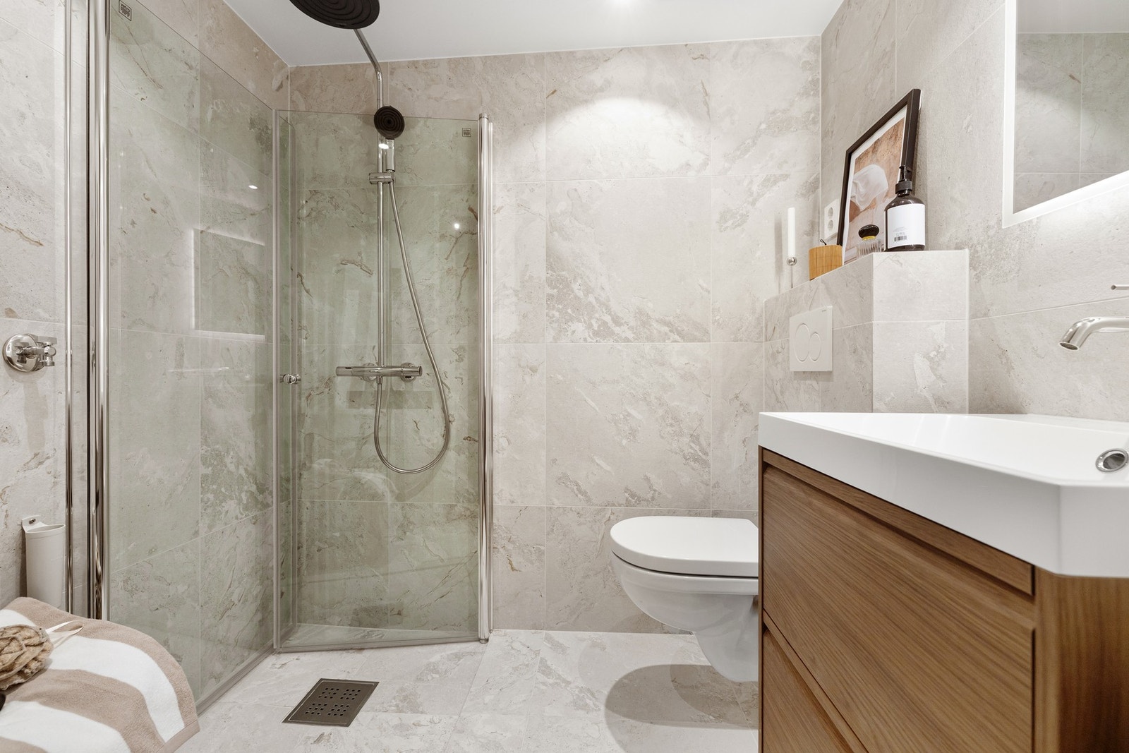 Romslig dusjnisje med innfellbare dører i glass. Waterfall- og hånddusj. Galleribilde