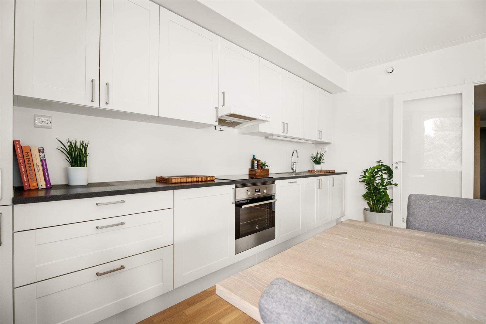 Integrerte hvitevarer og avtrekksvifte sikrer effektiv matlaging på kjøkkenet. Galleribilde