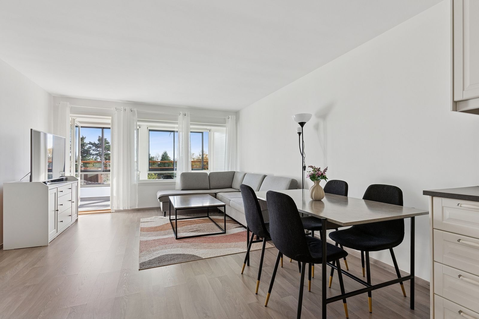 Åpen stue/kjøkkenløsning med direkte utgang til innglasset balkong Galleribilde