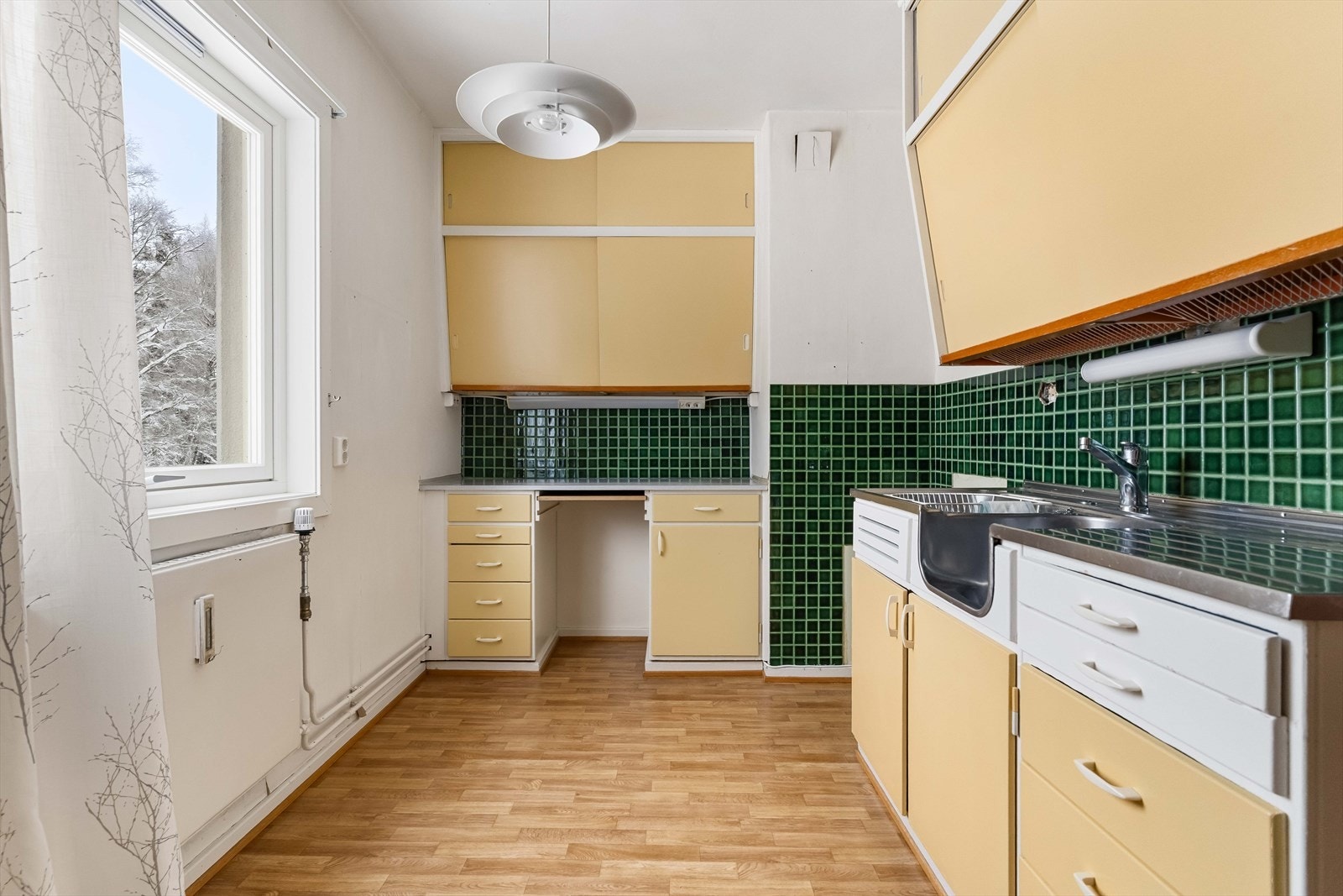 Kjøkkenet er separat og har en eldre innredning med glatte fronter, nedfelt oppvaskkum og ettgreps blandebatteri. Galleribilde