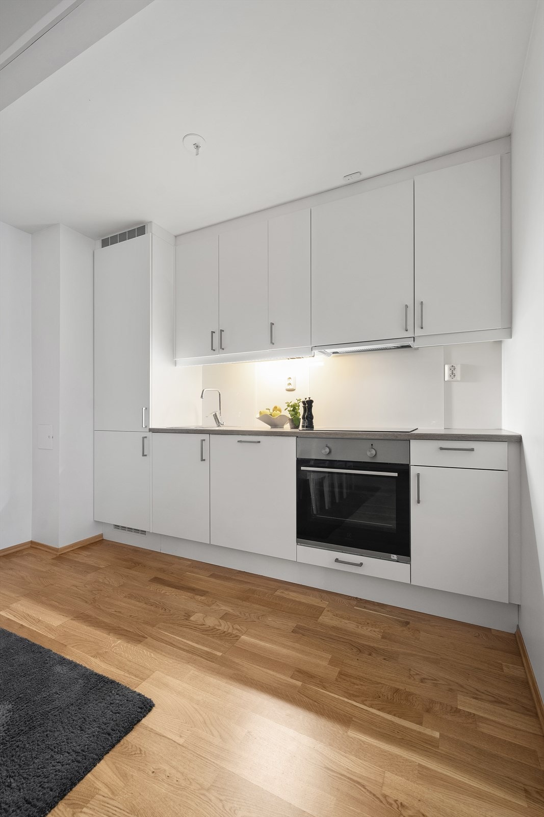 Lyst og pent kjøkken med integrerte hvitevarer. Galleribilde