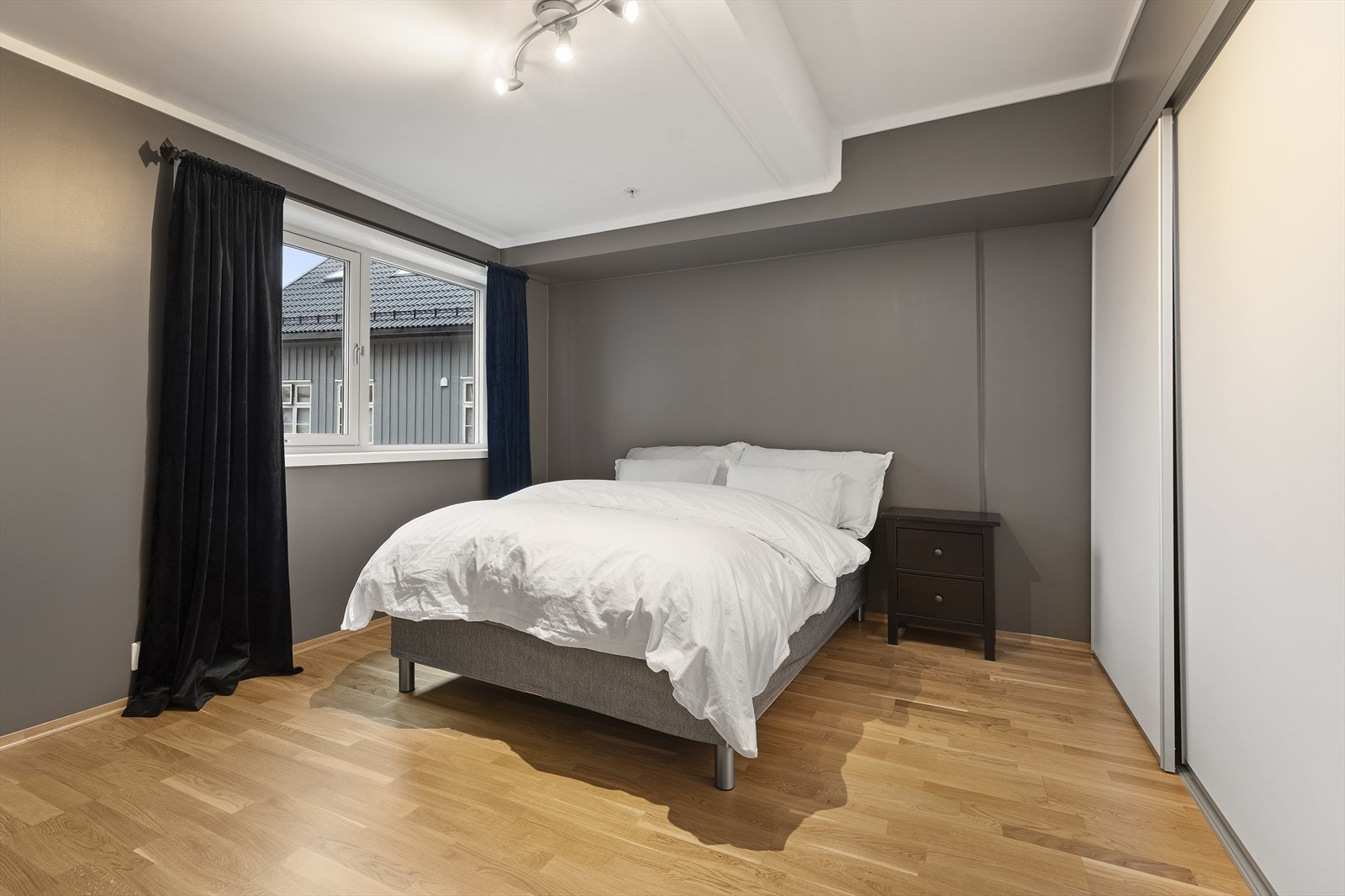 Romslig hovedsoverom i dag innredet med bred seng, nattbord på begge sider og kommode. Galleribilde