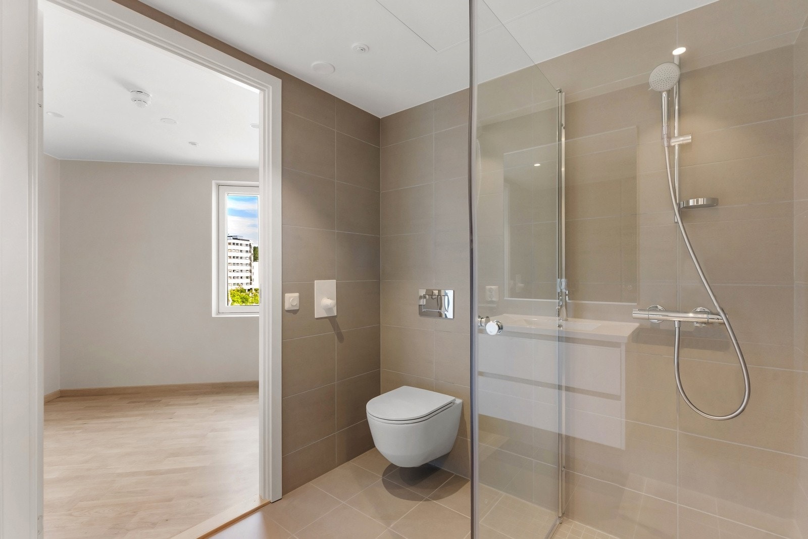 Badet er utstyrt med dusjnisje med glassdører, vegghengt toalett og servant med innredning. Opplegg for vaskemaskin og vannbåren varme i gulv. Galleribilde