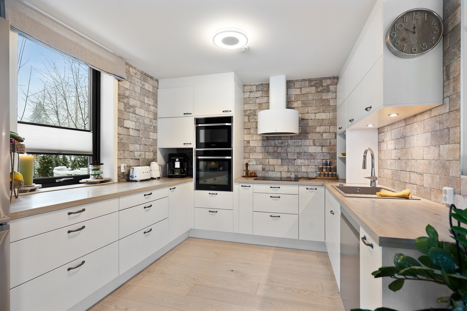 Kjøkkenet er innredet med hvite slette skap og skuffefronter. Her er det gode arbeidsforhold for den som er glad i å briljere på kjøkkenet. Galleribilde