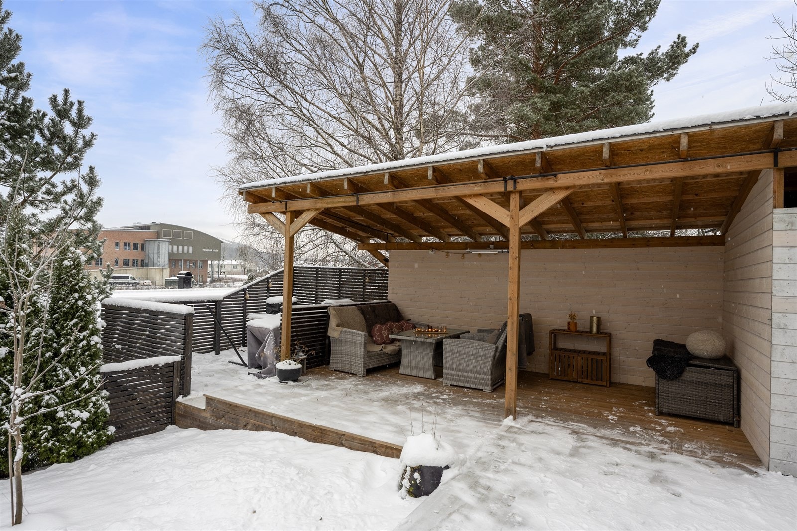 I hagen utenfor første etasje er det satt opp en overbygget uteplass. Her er det lunt og godt å sitte utover sommerkveldene. Galleribilde