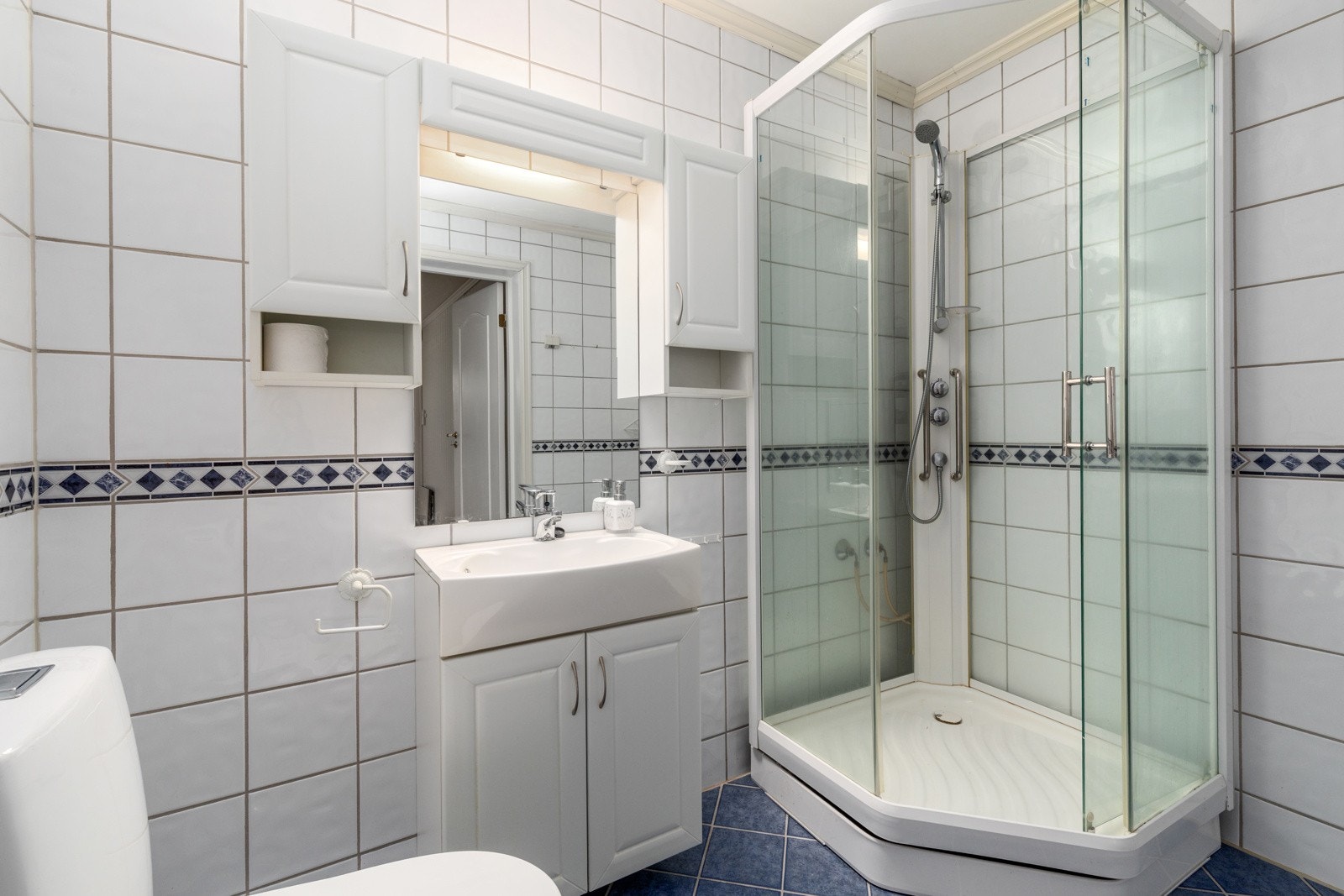 Badet har flislagte gulv og vegger med vegghengt servantinnredning. Galleribilde