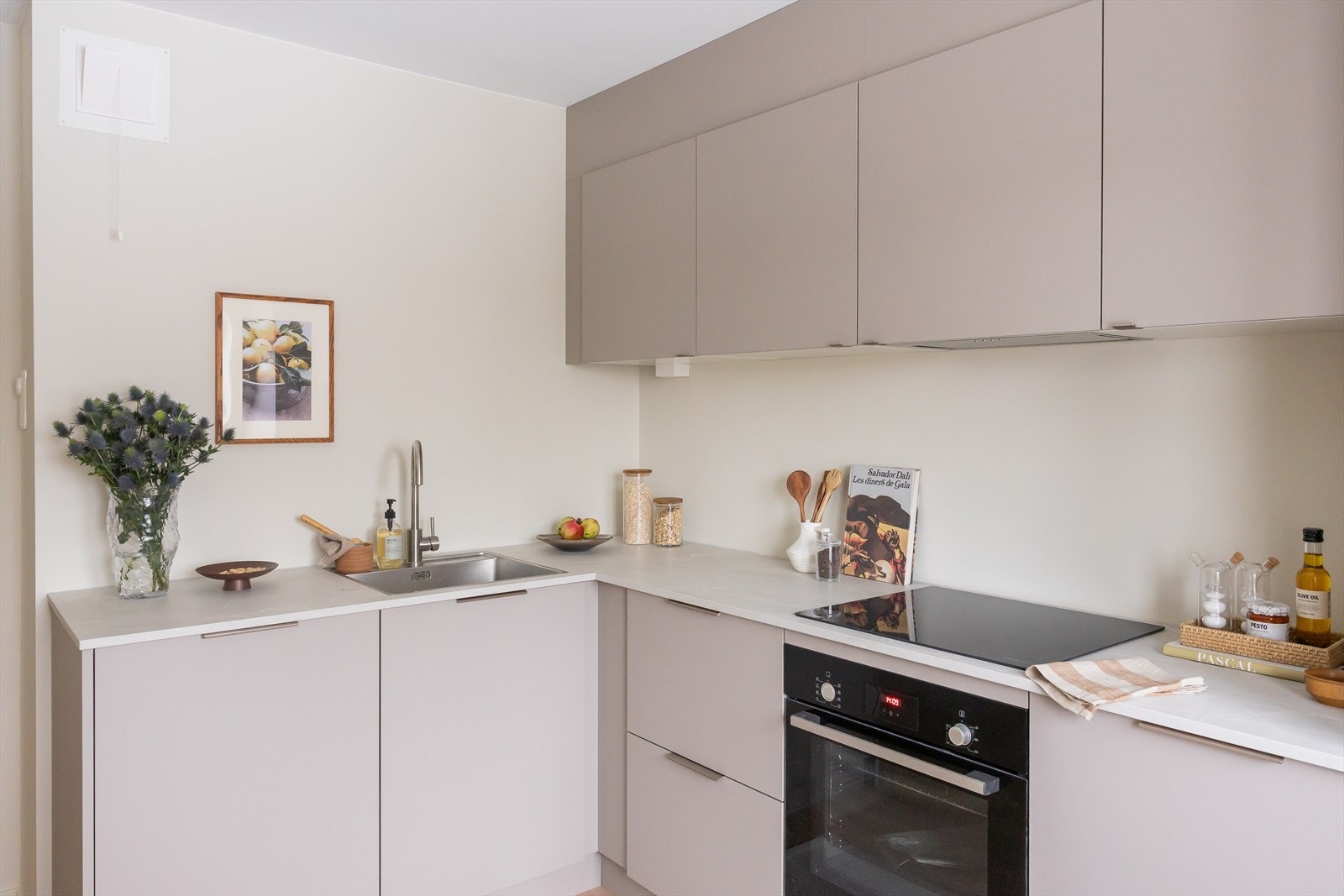 Kjøkkeninnredningen har glatte fronter, overskap og laminat benkeplate med nedfelt vaskekum - moderne og lekkert. Galleribilde