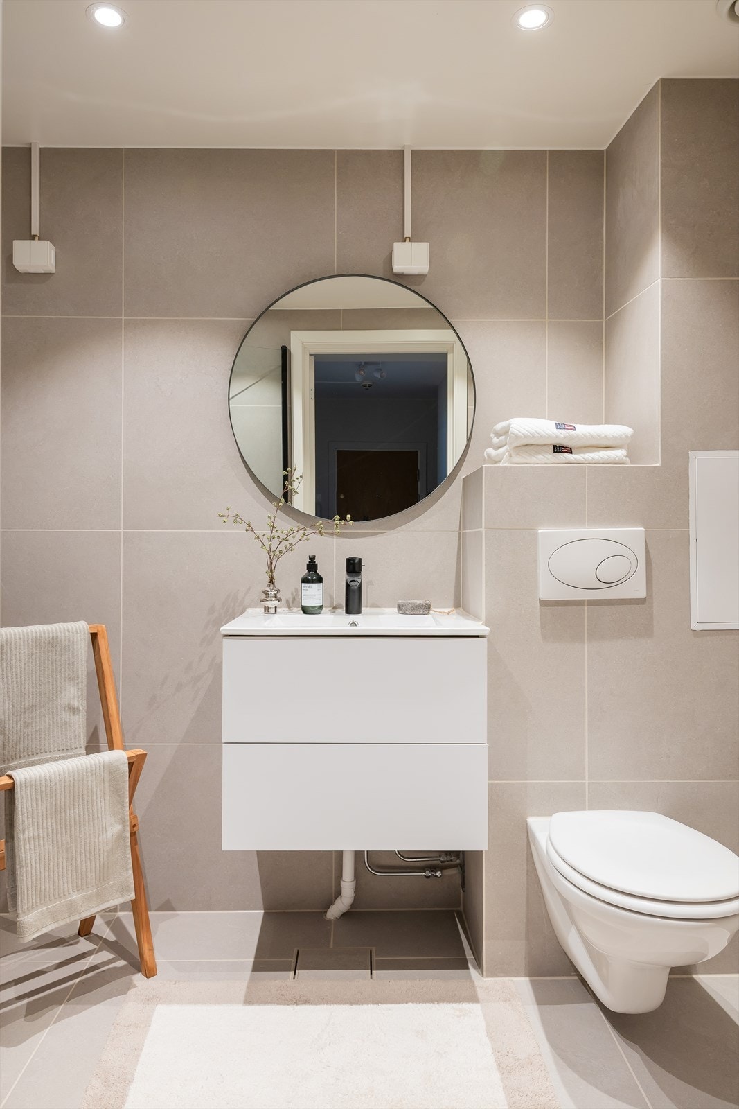 Videre er badet innredet med vegghengt klosett og servant nedfelt i baderomsinnredning. Galleribilde