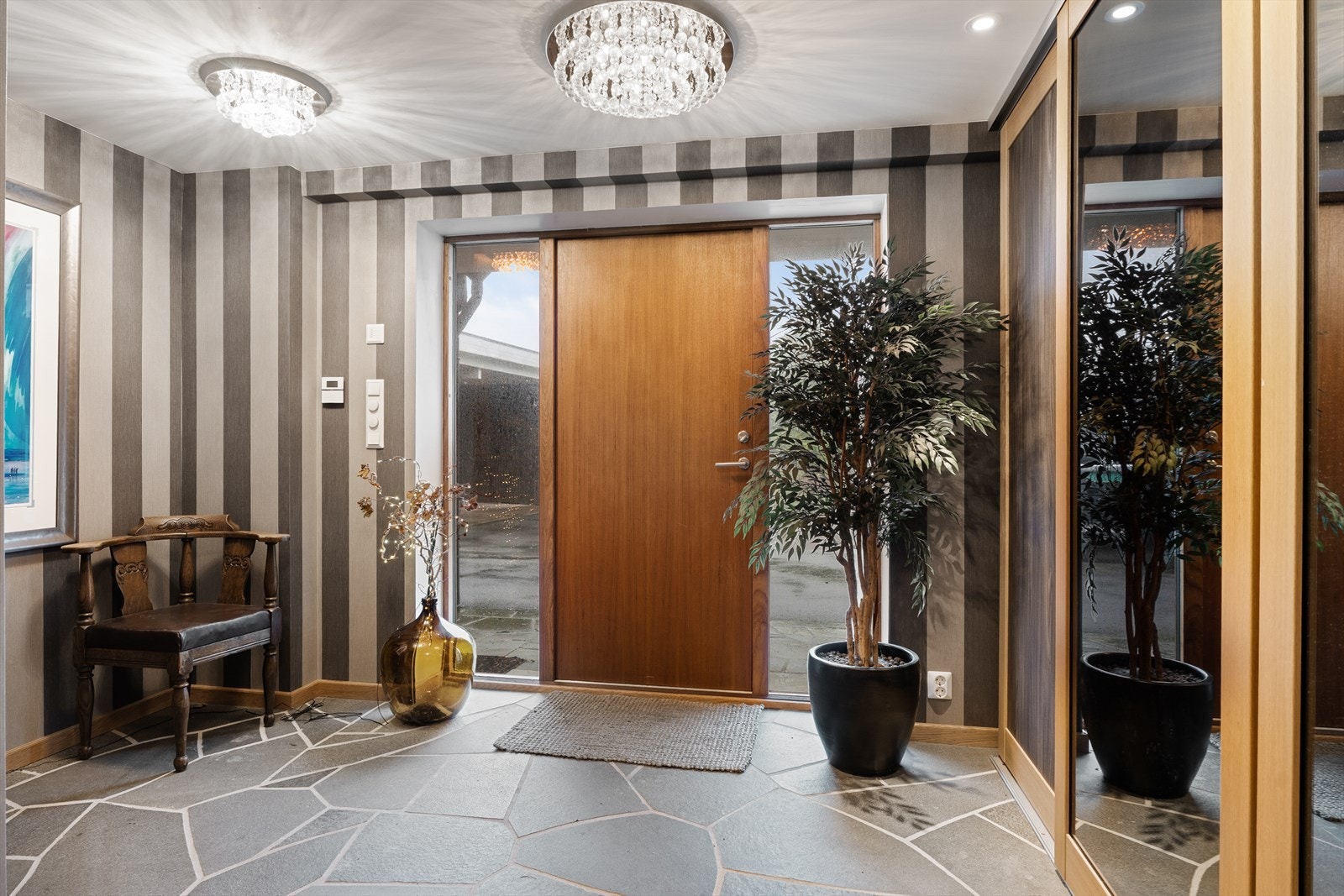 Hall/entré i undetasjen med skifergulv og stor skyvedørsgarderobe med god plass til yttertøy Galleribilde