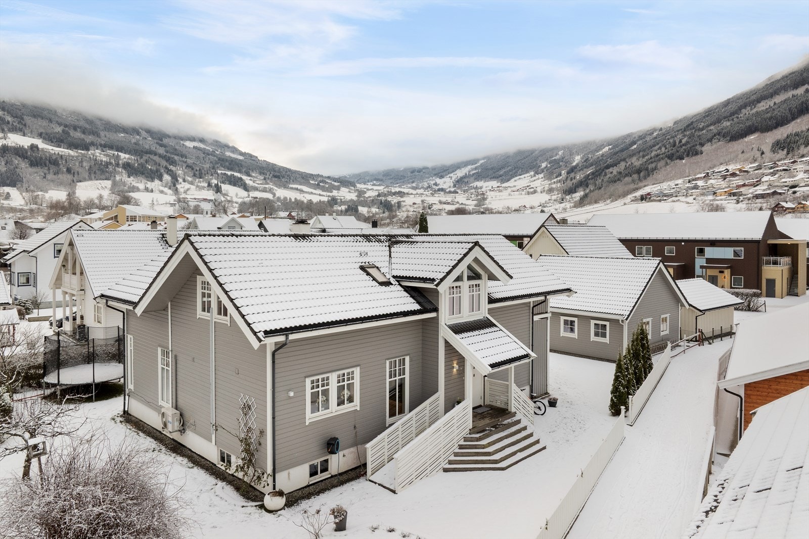 Tomta er flat og opparbeida med gruslagt tun, steinlagte ganbaner, plen med busker og planter, og terrasse. Galleribilde