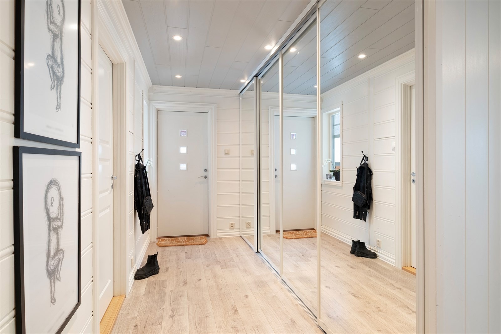Velkomen inn! Lyst og innbydande gangareal med spottar i himling og stor skyvedørsgarderobe med spegel i front. Galleribilde