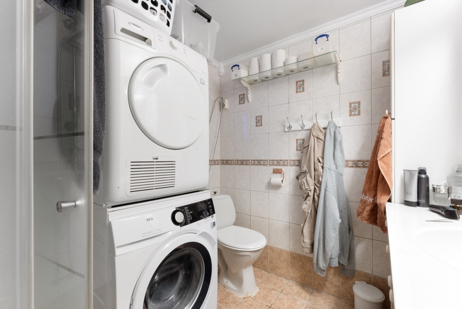 Flislagt bad med dusj, toalett, servant og opplegg for vaskemaskin Galleribilde