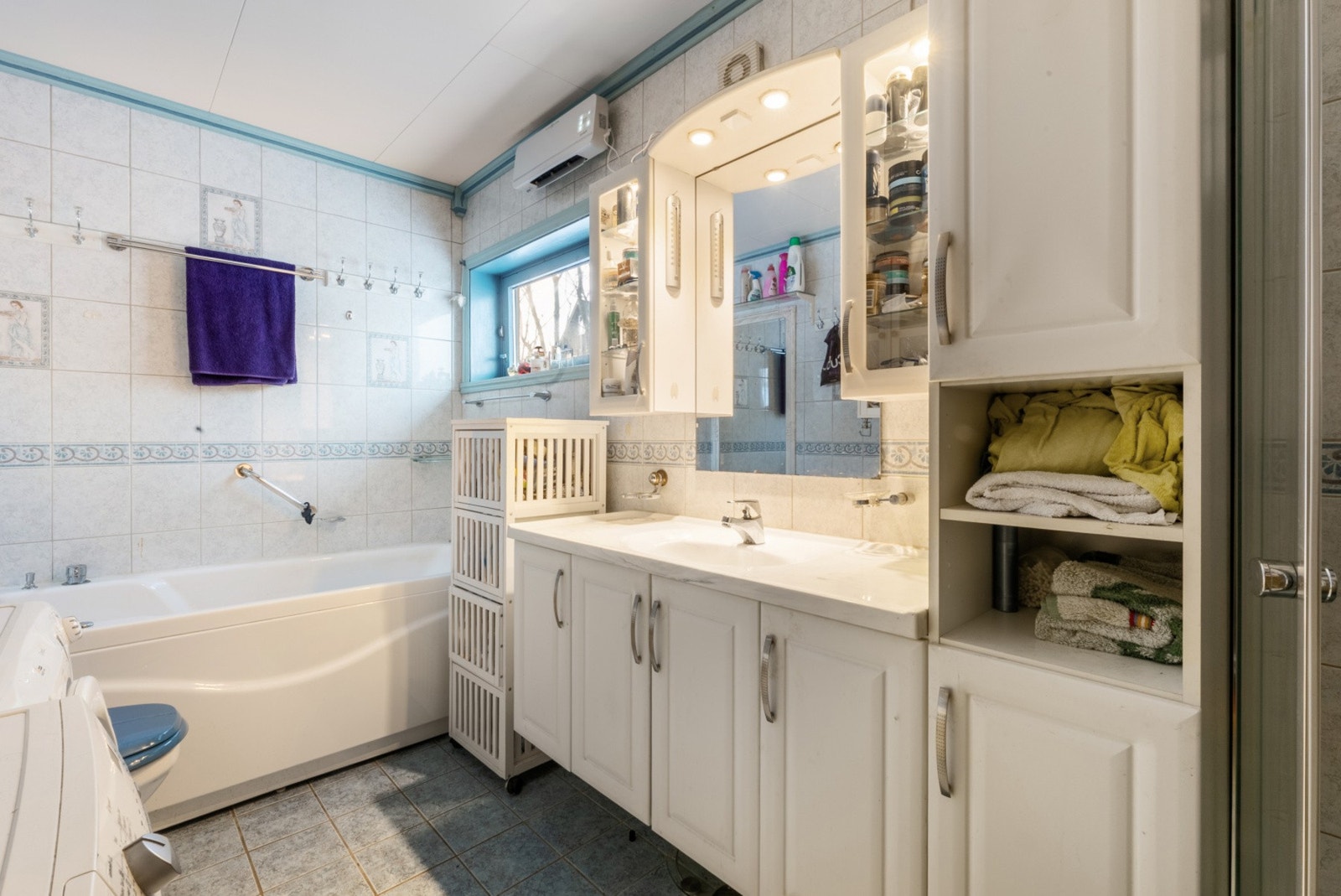 Badet er flislagt og har godt med oppbevaringsplass i skuffer og skap Galleribilde