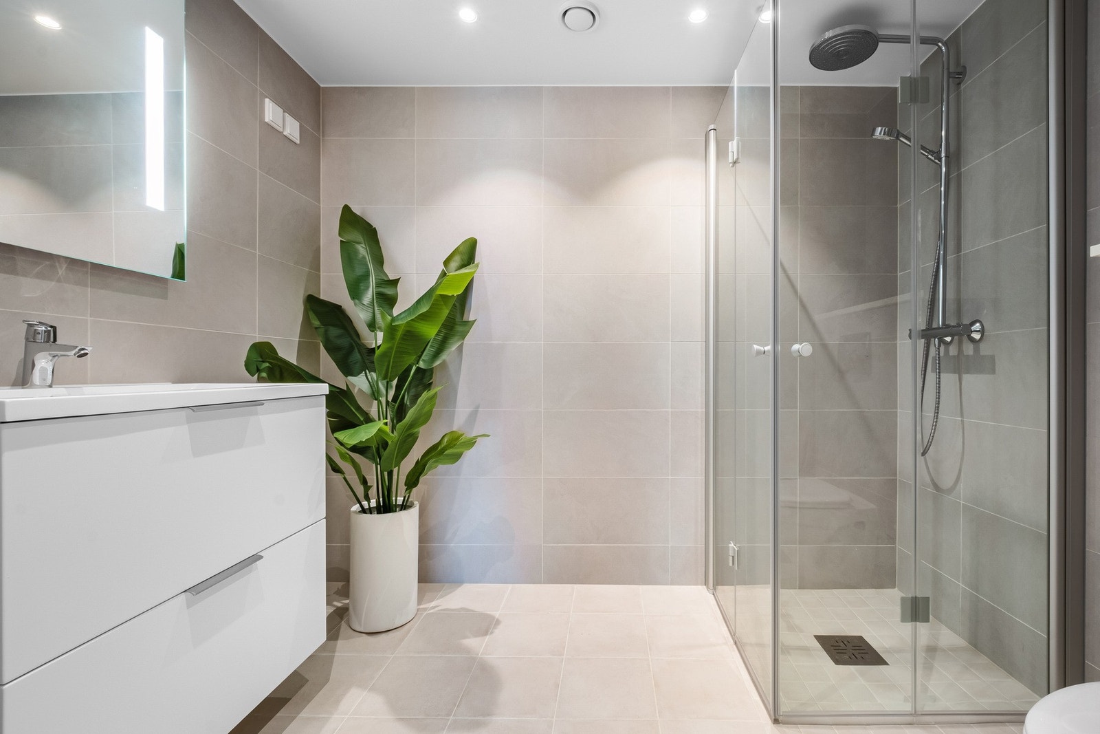 Delikat og flislagt bad/vaskerom med elektriske varmekabler i gulv. Det er opplegg for vaskemaskin. Galleribilde