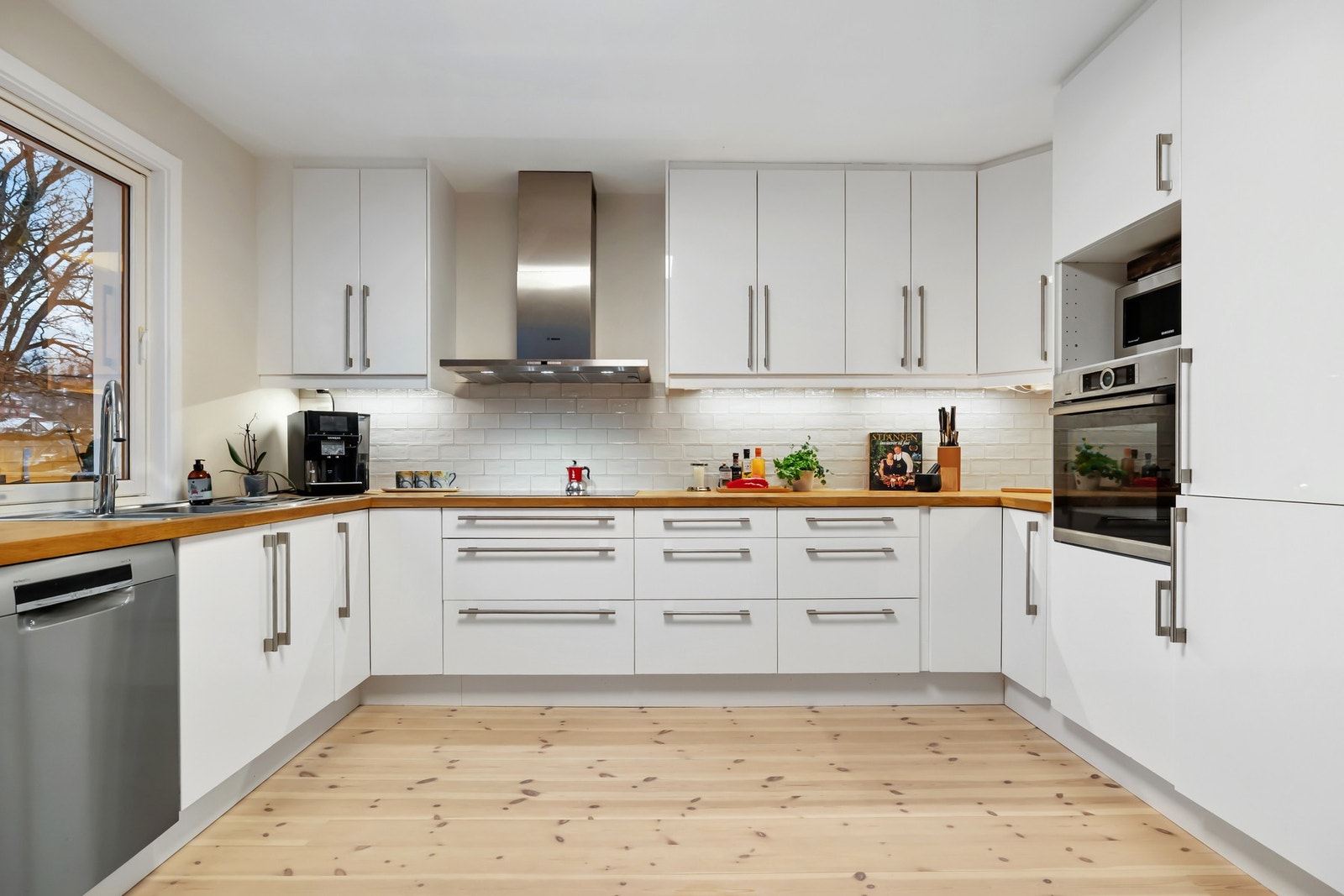 Kjøkkeninnredningen har lyse, glatte fronter og en benkeplate i tre. Galleribilde