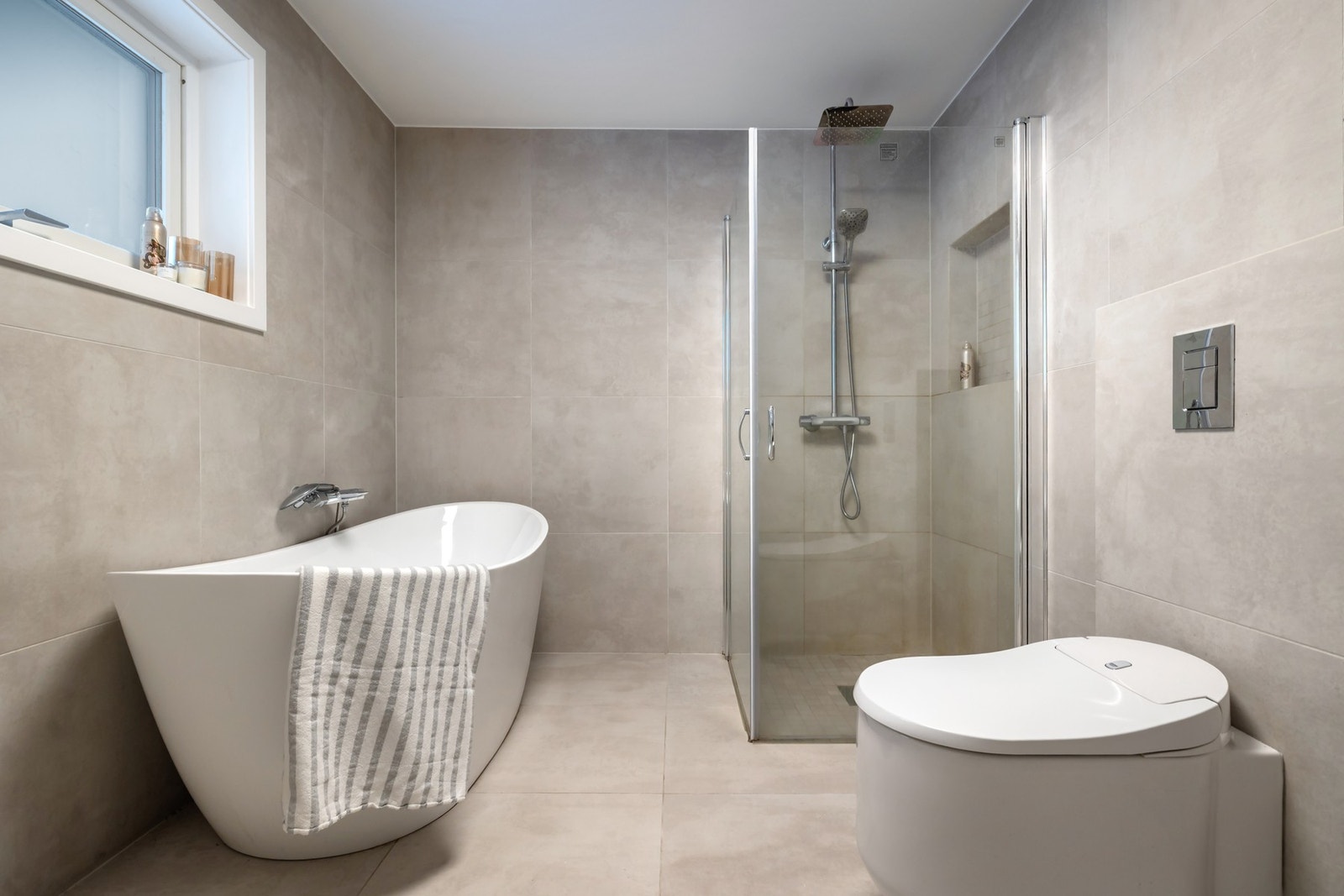 Badet er utstyrt med et frittstående badekar, dusjhjørne med glassdører og et bidetoalett, her er det også opplegg for vaskemaskin. Galleribilde