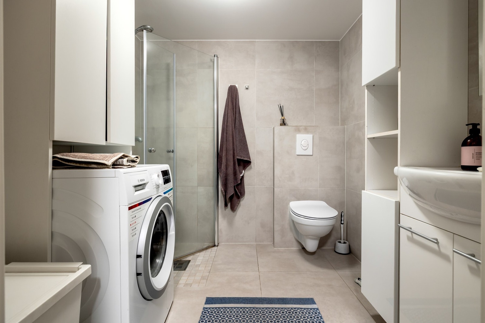 Badet tilhørende hybelen er innredet med dusjhjørne, vegghengt toalett, servant og opplegg for vaskemaskin. Galleribilde