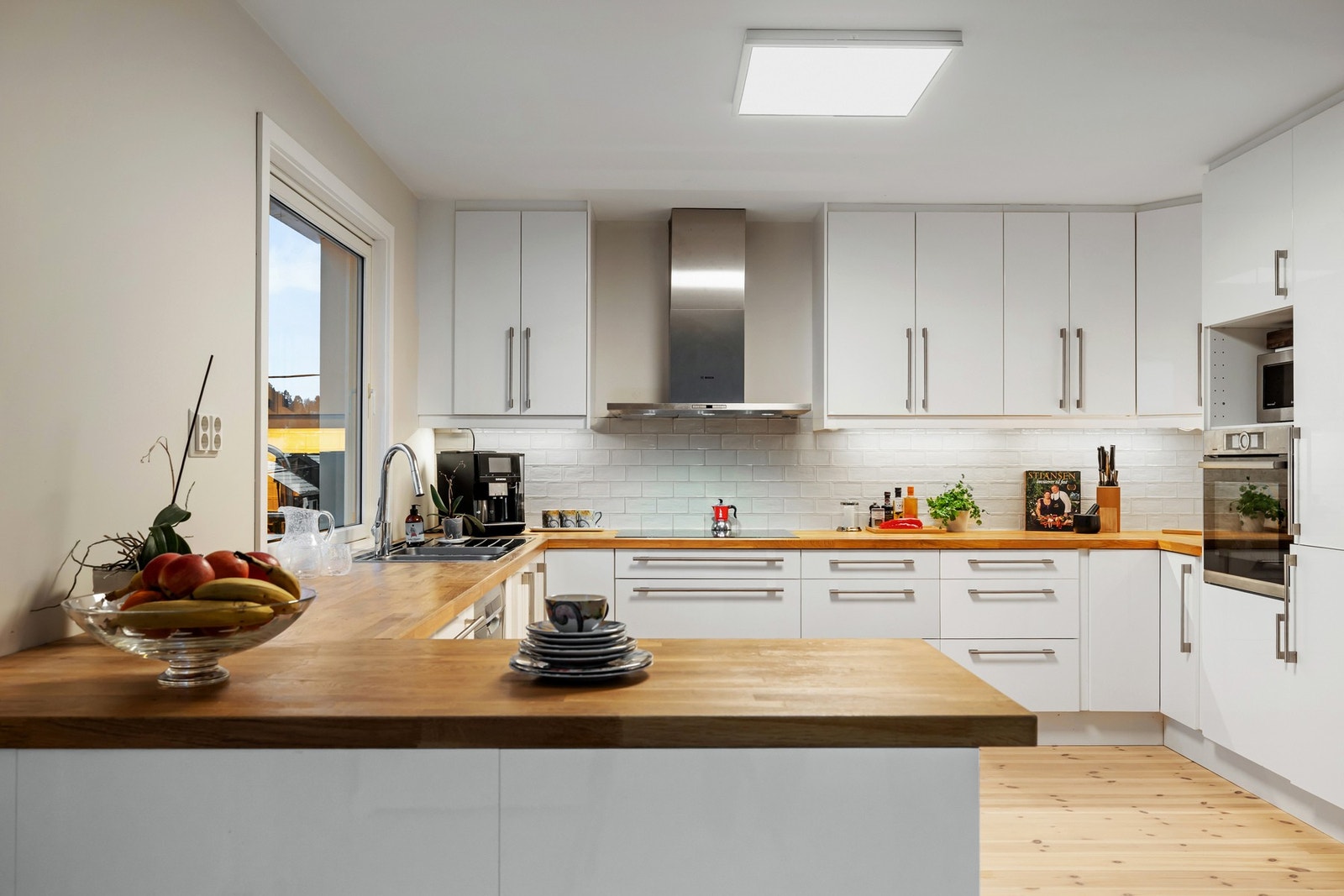 Halvøyen gir god arbeidsflate og bidrar til en praktisk og sosial løsning med ekstra benke- og oppbevaringsplass. Galleribilde