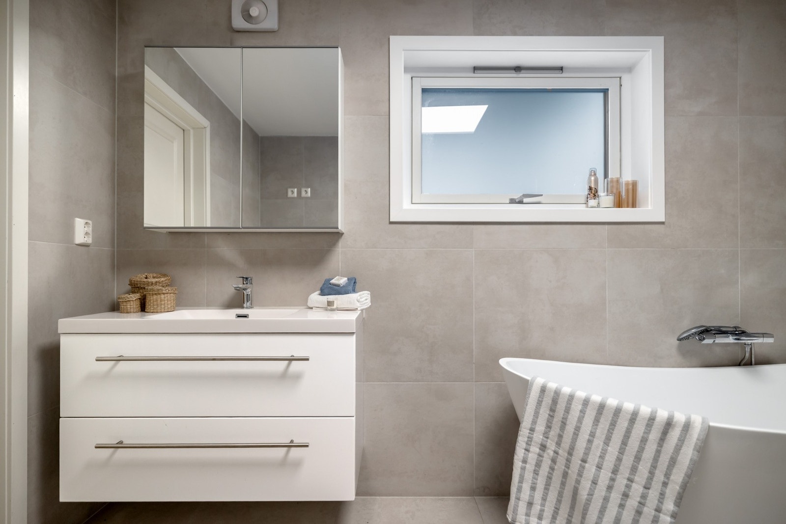 Badet er innredet med en servant med romslig baderomsinnredning og speilskap. Galleribilde