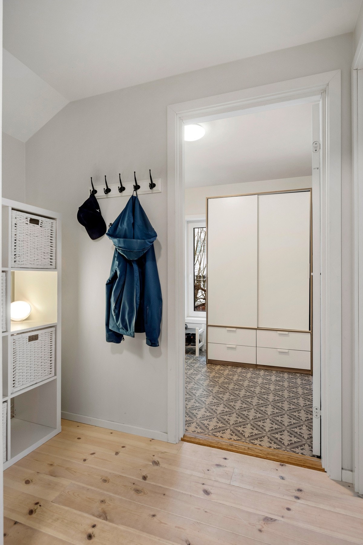Entréen er lys og romslig, med god plass til oppbevaring av yttertøy og sko. Entréen er innredet med et garderobeskapmes skap og hyller. Videre inn i gangen er det montert praktiske knagger. Galleribilde