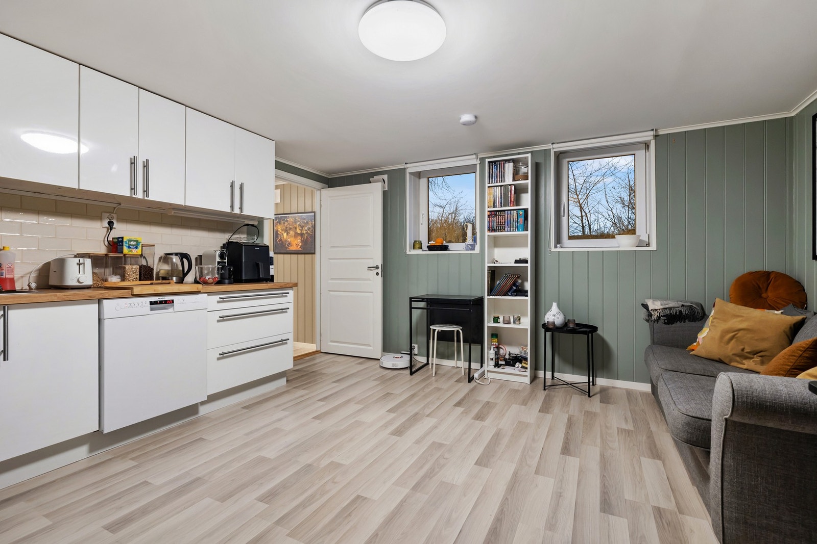 I underetasjen finner du en hybeldel egen inngang, Rommet benyttes i dag som en kombinert stue- og kjøkkenløsning, med god plass til både sofagruppe og spiseplass. Galleribilde