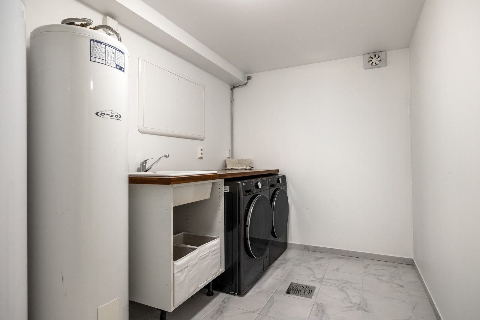 Teknisk rom / Vaskerommet er innredet med servant, benkeplass, opplegg for vaskemaskin og tørketrommel. Galleribilde