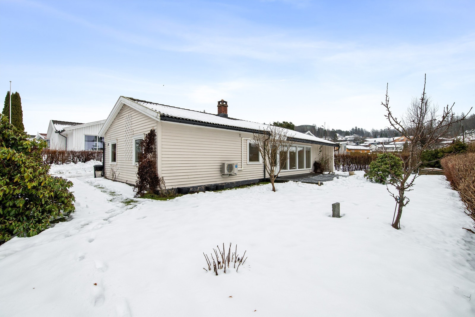 Mot vest og rundt store deler av boligen finnes det også arealer med gressplen - perfekt til lek og moro for både store og små. Hagen er godt skjermet fra veien med hekk, slik at de minste kan leke i trygge omgivelser. Galleribilde