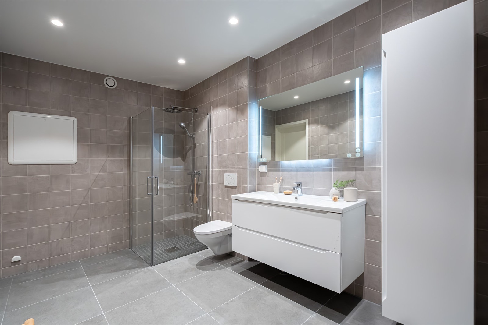 Speil med integrert lys, servant og skuffer. Gulvvarme. Downlights. Det er opplegg for vaskemaskin/tørketrommel. Galleribilde