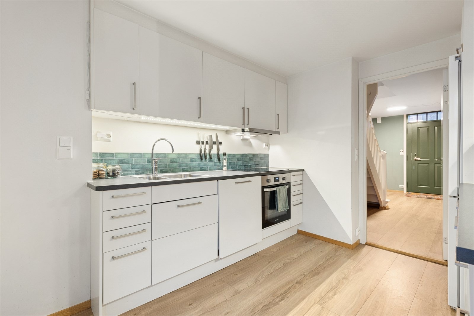 Kjøkkenet er utstyrt med integrert stekeovn, oppvaskmaskin og platetopp, samt et frittstående kjøl/fryseskap. Rommet har en kjøkkenventilator med avtrekk ut. Galleribilde