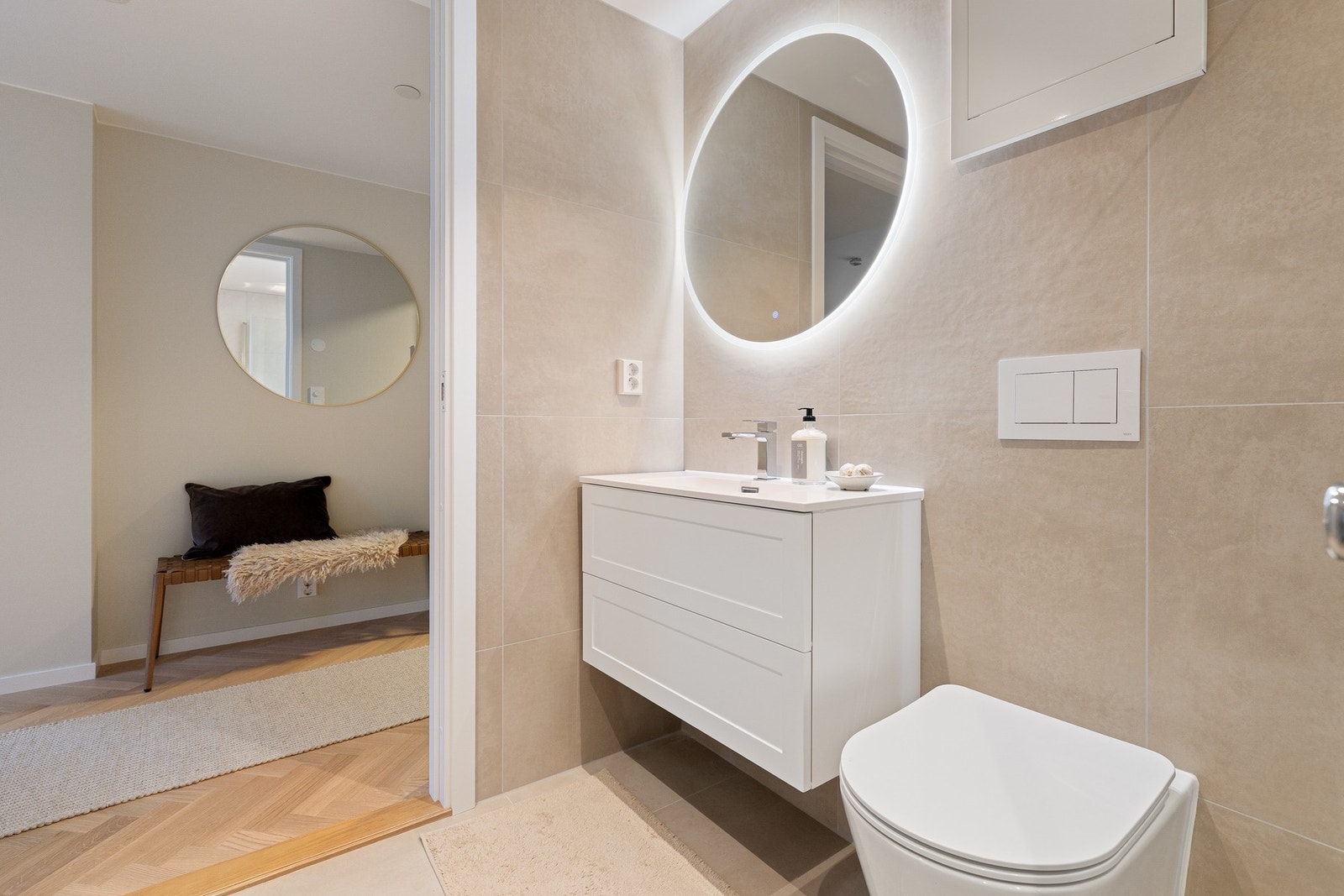 Innredningen består av lyse baderomsmøbler med god oppbevaringsplass, ovalt speil med integrert LED-belysning, vegghengt toalett og dusjhjørne. Galleribilde