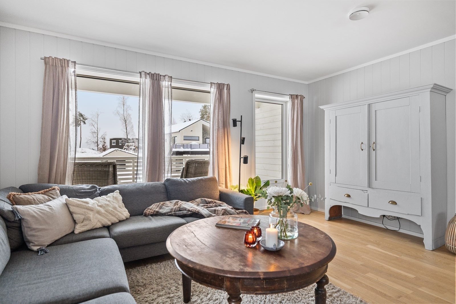 Stuen har flere vinduer som gir naturlig lys og utsikt til nabolaget. Galleribilde