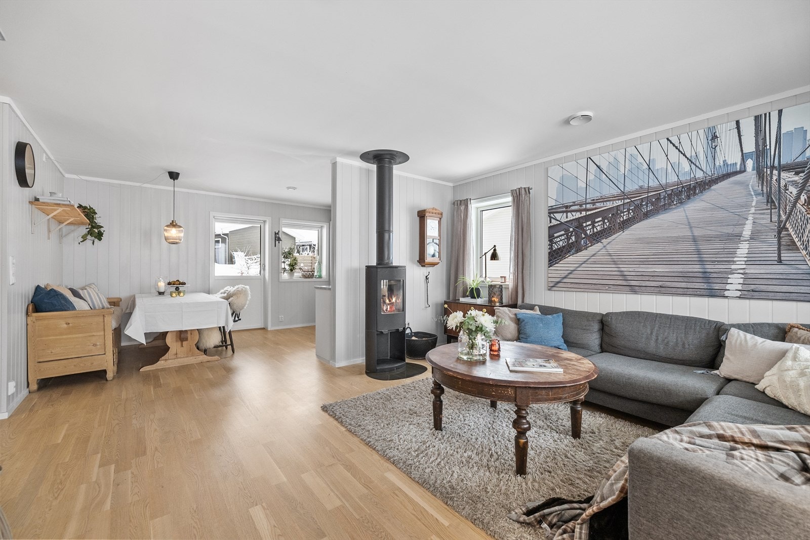 Lyst parkettgulv og en rentbrennende peisovn gir stuen en varm atmosfære. Galleribilde