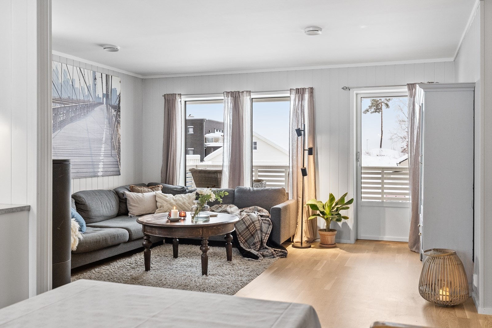 Store vinduer i stuen gir godt med lys og utsikt til uteområdet foran bygget. Galleribilde