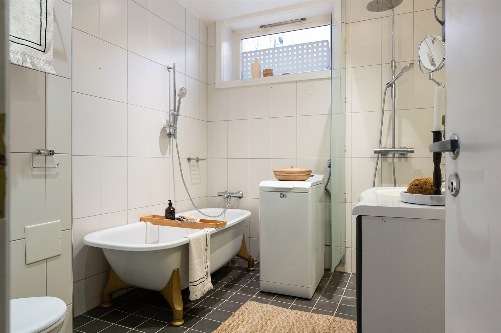 Her er det dusjhjørne med svingbar glassdør og praktisk opplegg for vaskemaskin. Galleribilde