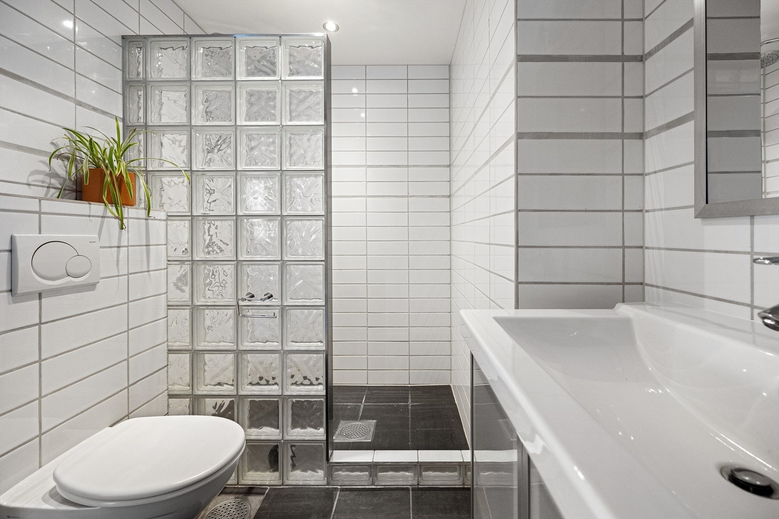 Romslig dusjnisje og vegghengt toalett. Galleribilde