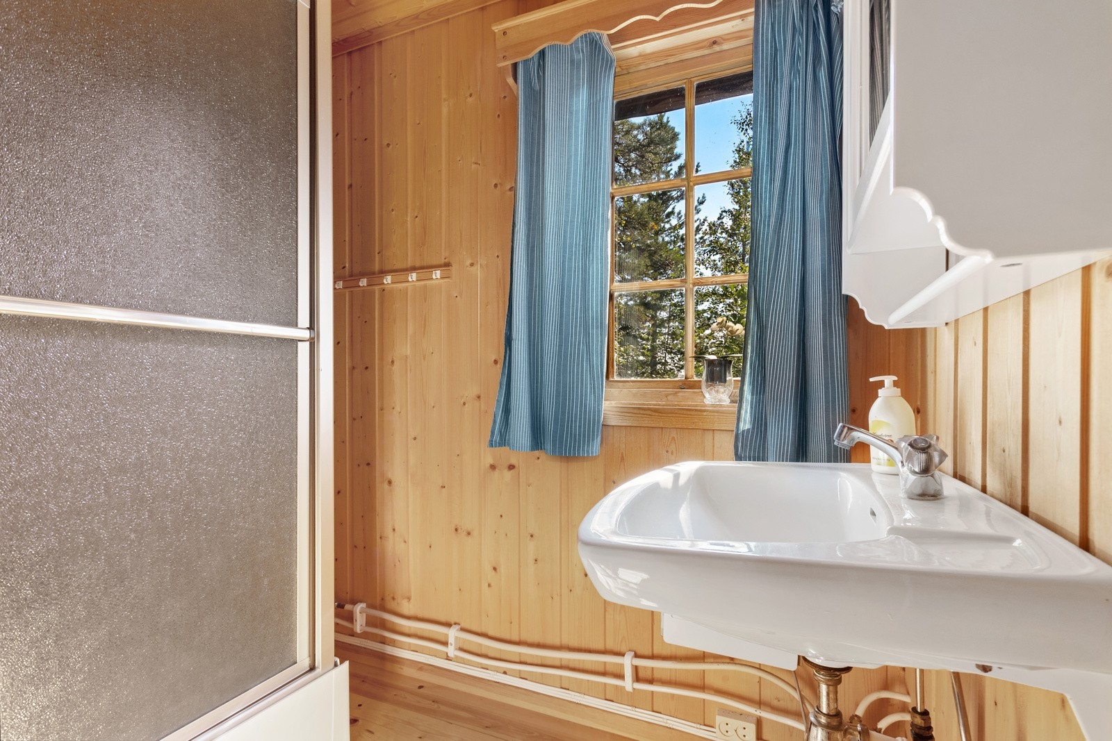 Her finner du alt du trenger for daglig hygiene, med dusj, servant og toalett. Det lille vinduet slipper inn naturlig lys, og bidrar til et lyst og trivelig rom. Galleribilde