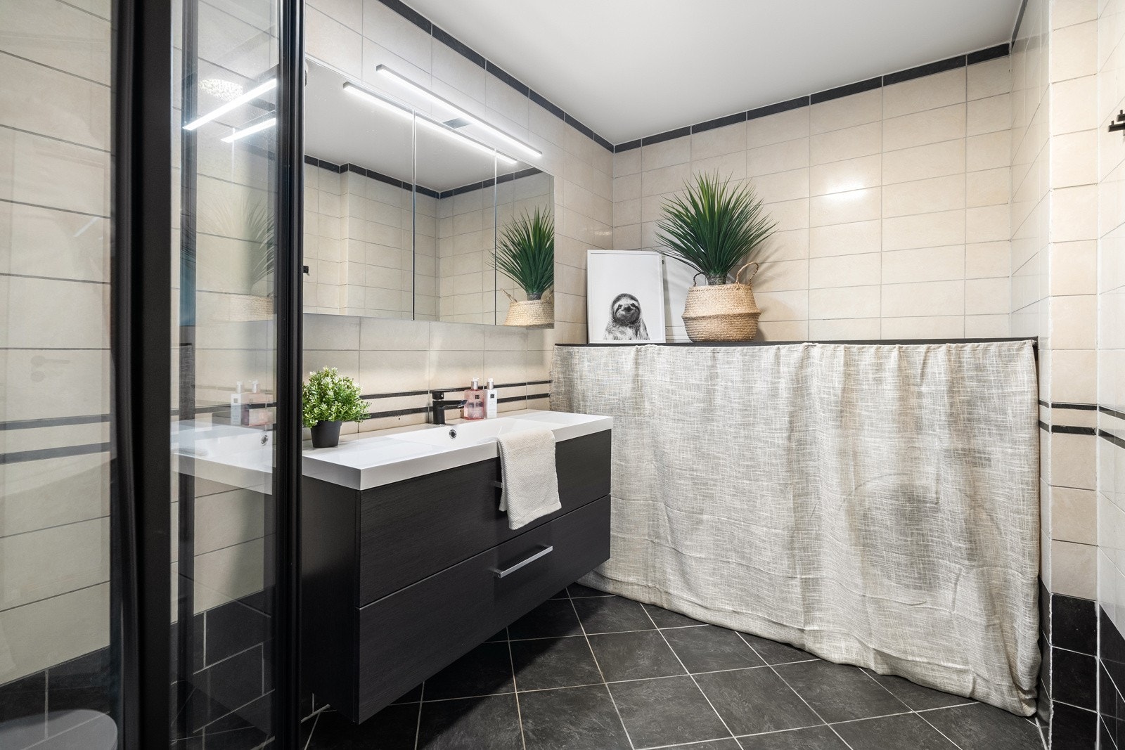 Badet er lyst og helfliset med varme i gulv. Galleribilde