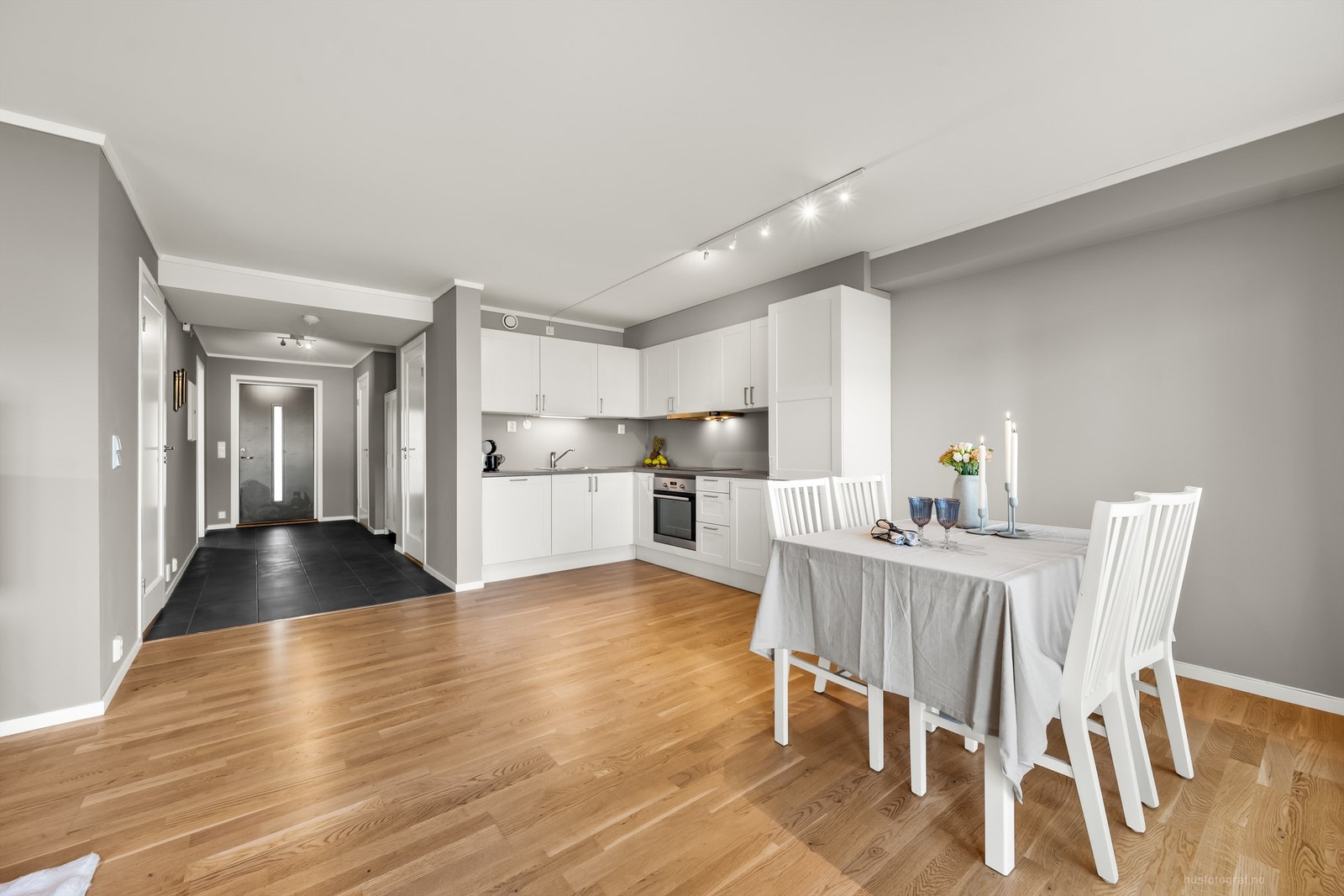 Åpen kjøkken- og stueløsning med sofaområde samt spiseplass Galleribilde