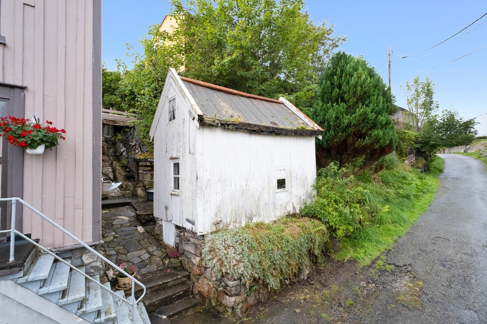 Døren på fremsiden av huset er til pynt, og man må gå mellom boligen og uthuset for å komme til inngangen på baksiden. Galleribilde