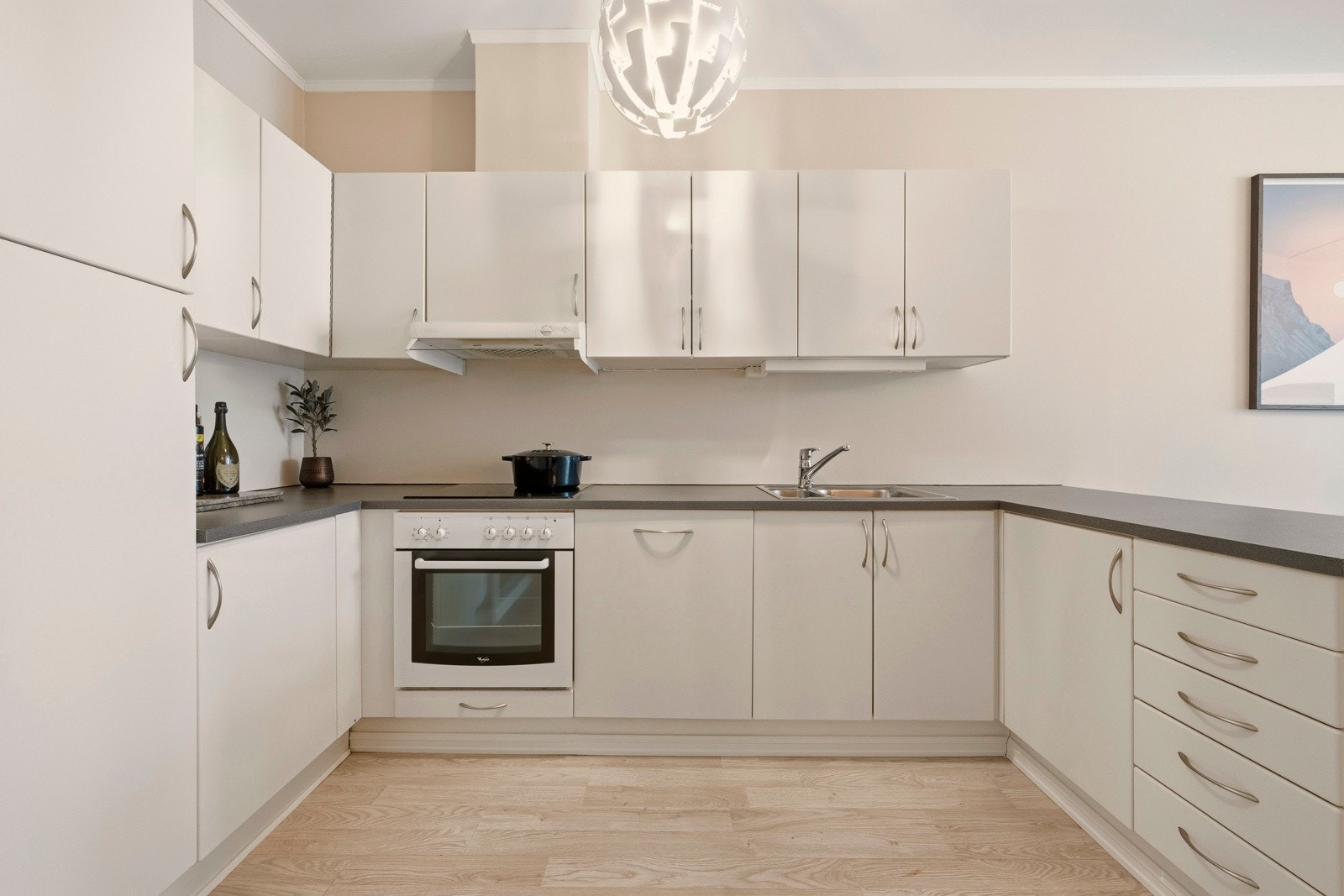 Kjøkkenet har integrerte hvitevarer som oppvaskmaskin, stekeovn, platetopp og kjøleskap. Galleribilde