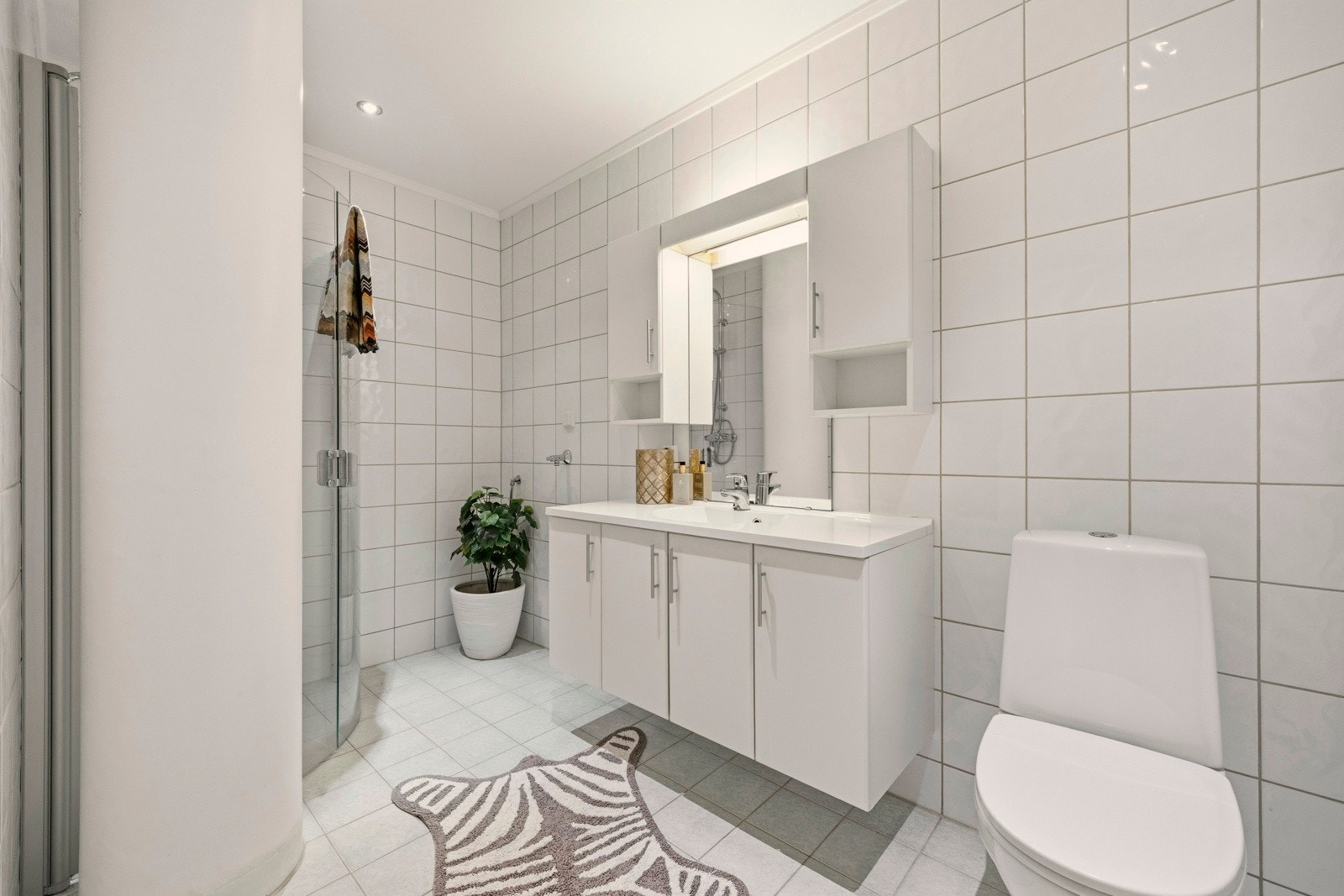 Pent, flislagt bad med varmekabler i gulvet og downlightsbelysning i taket. Galleribilde