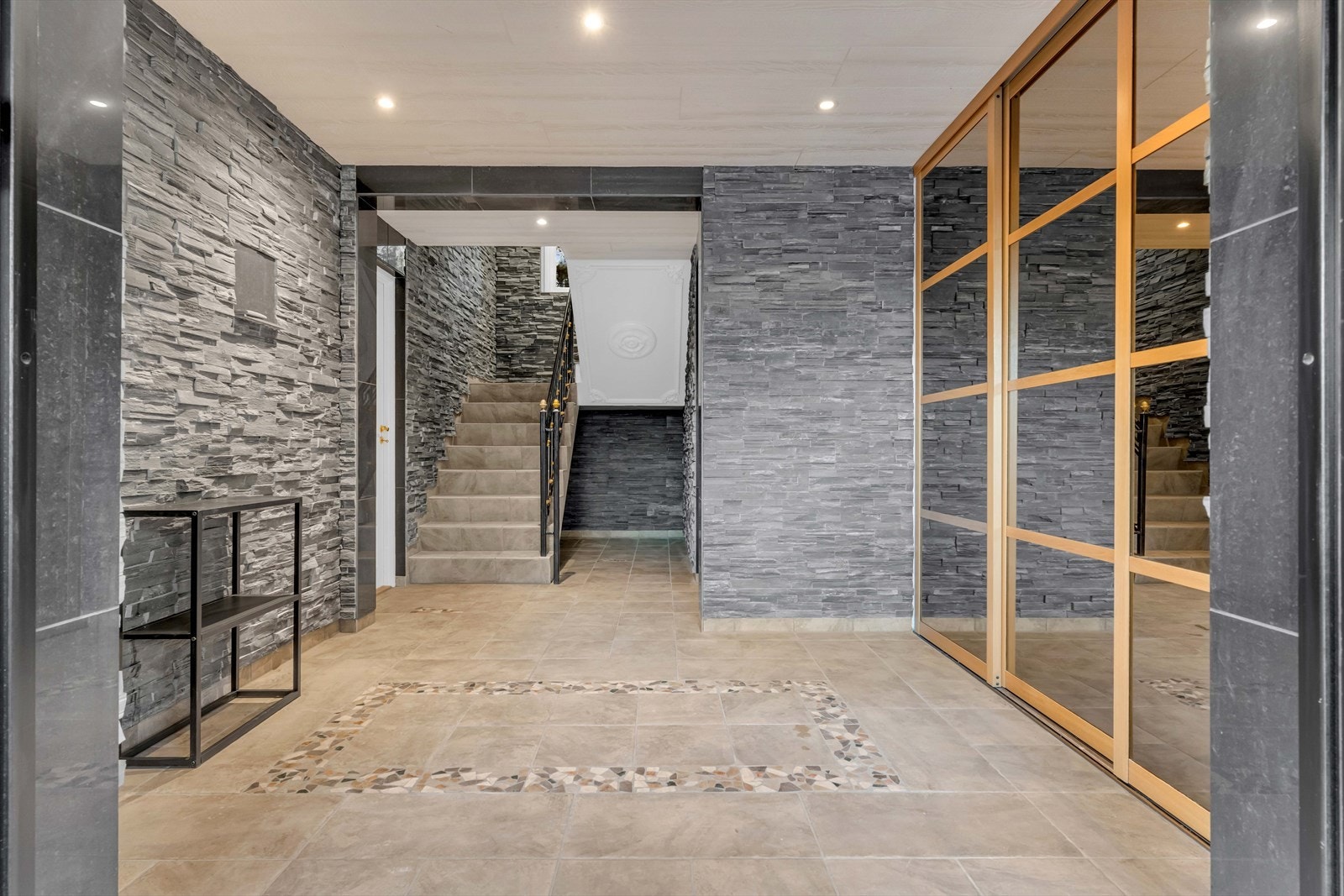 Herfra kommer man inn i en flislagt hall, hvor yttertøy og sko kan plasseres i skyvedørsgarderobe. Galleribilde