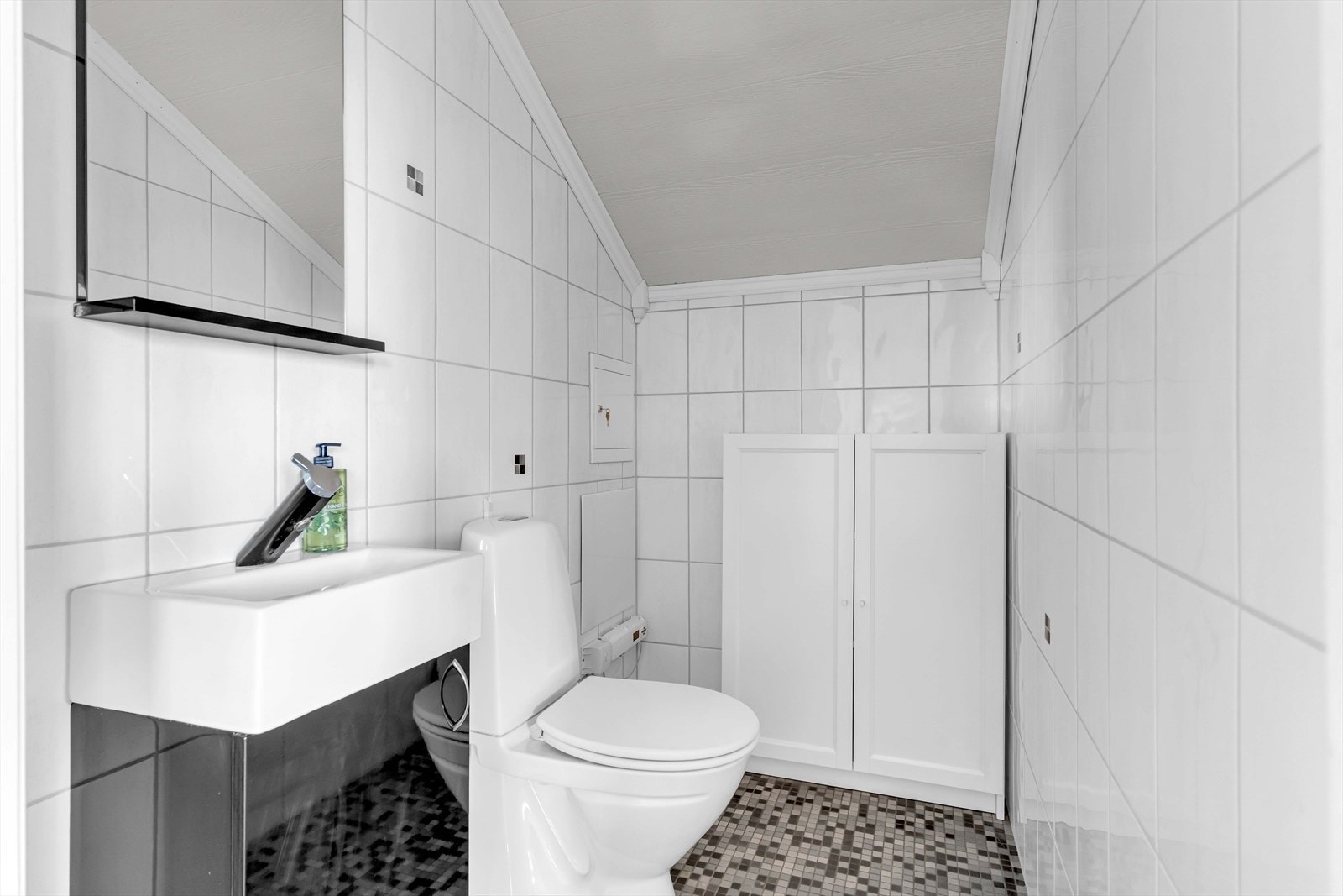 Fra stuen er det inngang til et toalettrom med flislagte overflater. Rommet består av gulvstående toalett og servant. Galleribilde